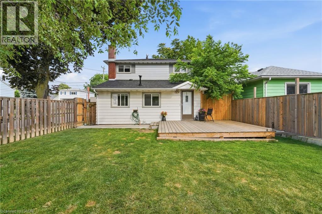 Expansive backyard featuring a manicured lawn, a wooden privacy fence, and a spacious deck - 432 Upper Sherman Avenue, Hamilton, ON - Outdoor