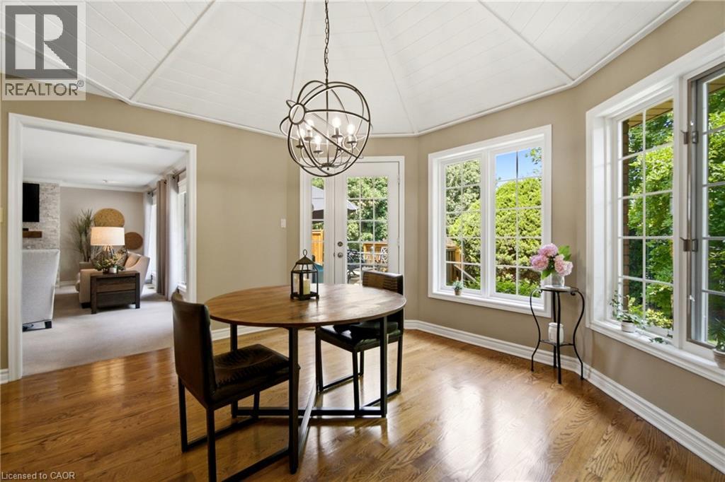 Dining area featuring wood-finish flooring, a white paneled cathedral ceiling, and an ornate spherical chandelier - 1090 Crofton Way, Burlington, ON - Indoor Photo Showing Dining Room