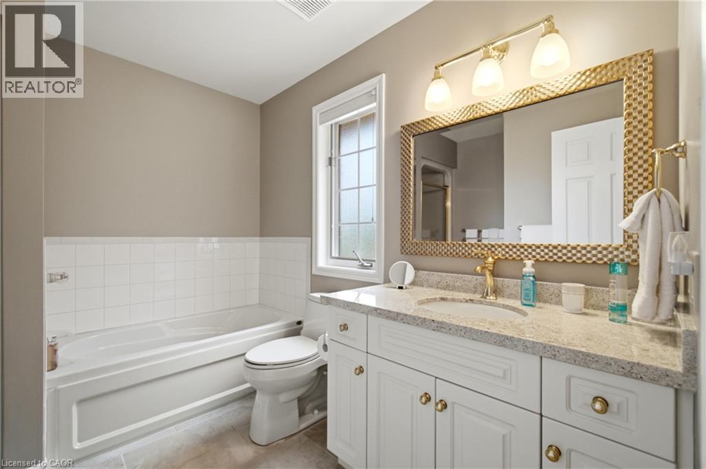 Bathroom vanity with a white cabinetry, light-toned countertop, and undermount sink - 1090 Crofton Way, Burlington, ON - Indoor Photo Showing Bathroom