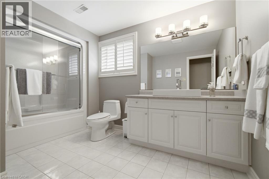 Bathroom featuring a white vanity with multiple cabinets, a rectangular vessel sink, and a large wall-mounted mirror - 1090 Crofton Way, Burlington, ON - Indoor Photo Showing Bathroom