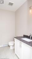 Bathroom featuring a white vanity with dark countertop, undermount sink, and chrome faucet - 