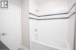 White subway tile shower surround with two black mosaic tile accent bands - 