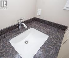 Integrated white sink with a chrome faucet set into a speckled countertop - 