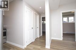 Interior entryway featuring a wood-finish flooring, recessed lighting, white doors with panel detailing, and a neutral wall color - 