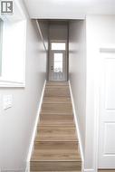 Staircase featuring wood-finish treads and white risers with painted walls - 