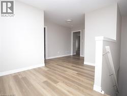 Open interior hallway with light wood-finish flooring - 
