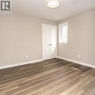 Neutral wall tones, wood-finish flooring, white trim, a double bifold door, and a single window with natural light - 