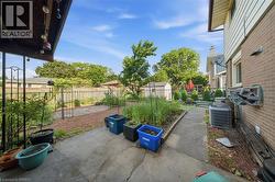 Expansive backyard featuring a concrete patio, established garden beds, and a storage shed - 