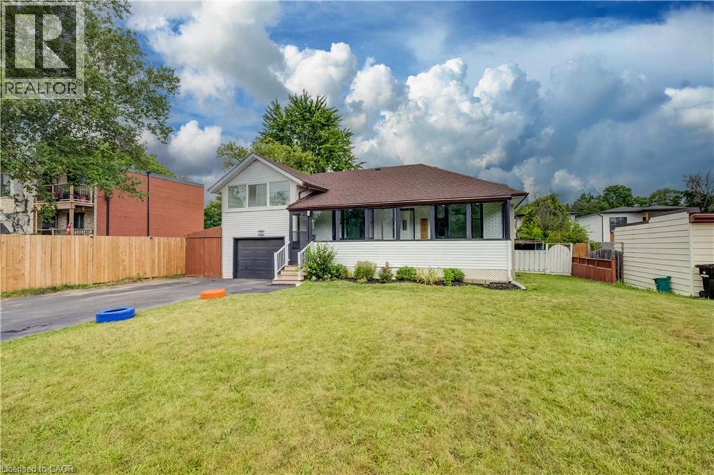 Single-story property featuring a white exterior, brown shingle roof, and an attached garage with a dark door - 182 Avalon Place, Kitchener, ON - Outdoor