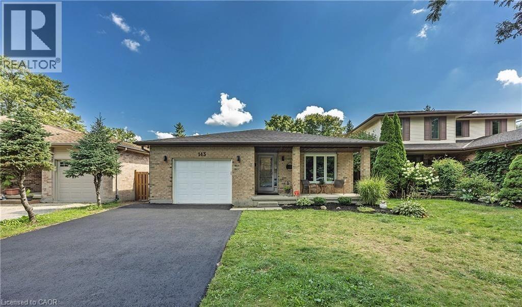 Brick facade residence featuring an attached single-car garage and a paved driveway - 143 Grenfell Place, London, ON - Outdoor With Facade