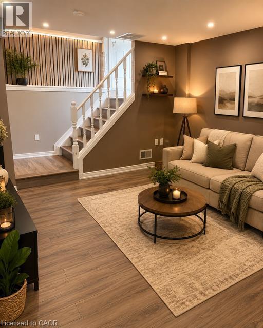 Lower-level living area featuring wood-finish flooring, recessed lighting, and a white balustrade staircase - 143 Grenfell Place, London, ON - Indoor Photo Showing Other Room