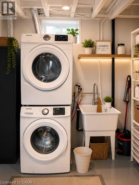 Dedicated laundry area featuring stacked appliances, a utility sink with a high-arc faucet, and an exposed beam ceiling - 143 Grenfell Place, London, ON - Indoor Photo Showing Laundry Room