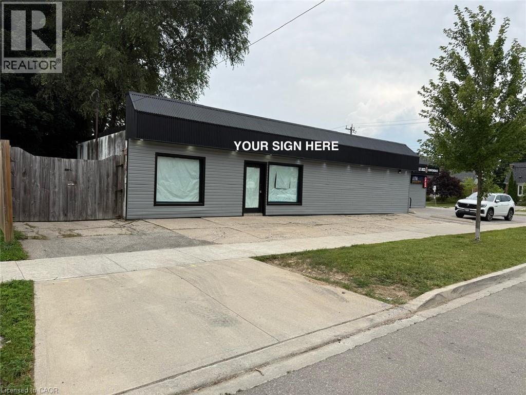 Commercial building with gray horizontal siding and a dark roofline - 116 St Clair Avenue, Kitchener, ON