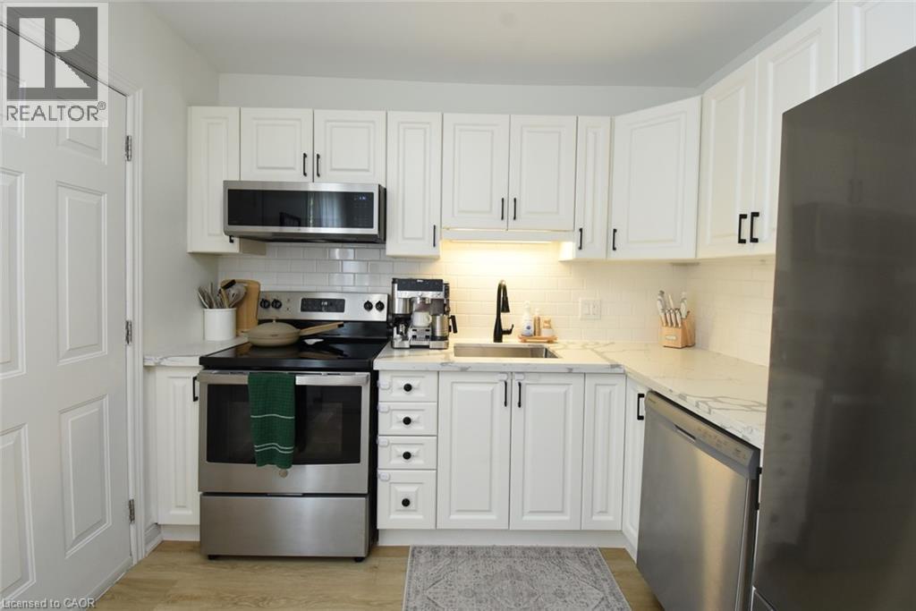 Contemporary kitchen featuring white cabinetry, stainless steel appliances, a subway tile backsplash, and light-toned countertops - 106 Belview Avenue, Hamilton, ON - Indoor Photo Showing Kitchen With Stainless Steel Kitchen With Upgraded Kitchen