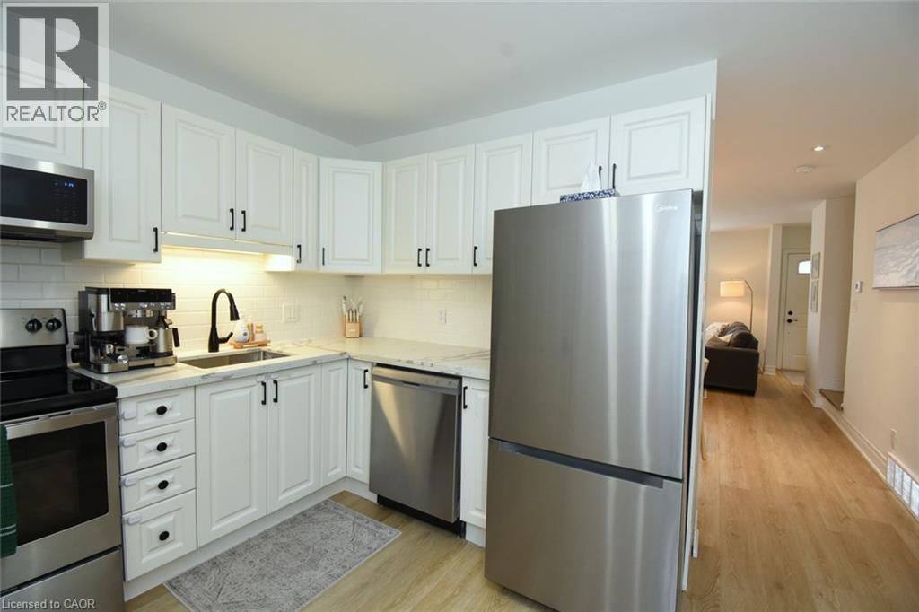 Modern kitchen featuring white shaker-style cabinetry, stainless steel appliances, a subway tile backsplash, and light-toned countertops - 106 Belview Avenue, Hamilton, ON - Indoor Photo Showing Kitchen With Stainless Steel Kitchen With Upgraded Kitchen