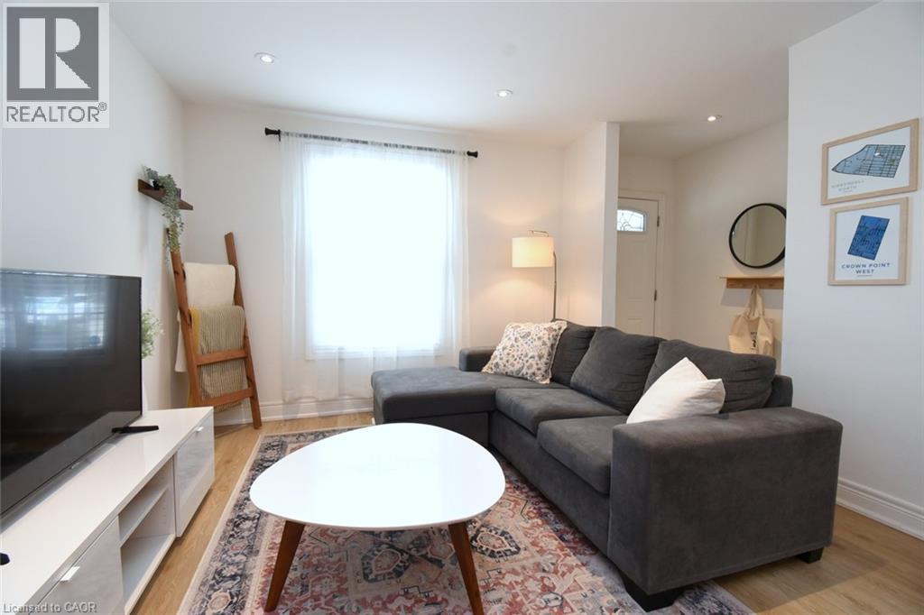 Bright living area featuring wood-finish flooring, recessed lighting, and white baseboards - 106 Belview Avenue, Hamilton, ON - Indoor Photo Showing Living Room