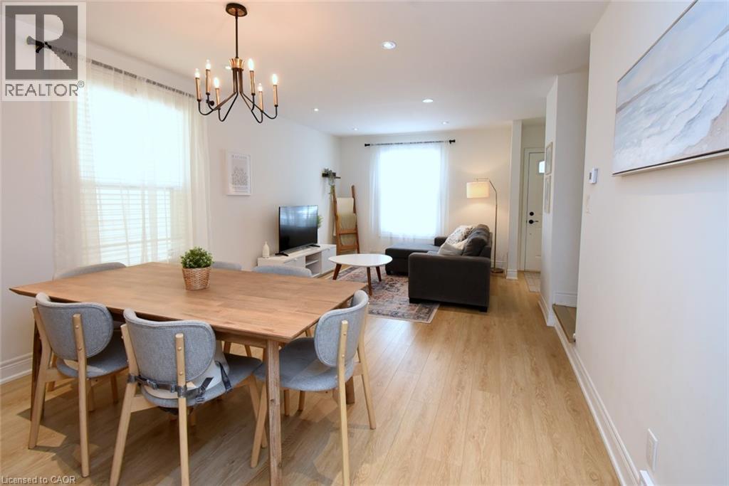 Open-concept living area with wood-finish flooring, recessed lighting, and a modern chandelier - 106 Belview Avenue, Hamilton, ON - Indoor Photo Showing Dining Room