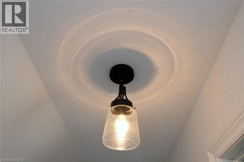 Black finish semi-flush mount light fixture with a seeded glass shade - 106 Belview Avenue, Hamilton, ON - Indoor Photo Showing Other Room