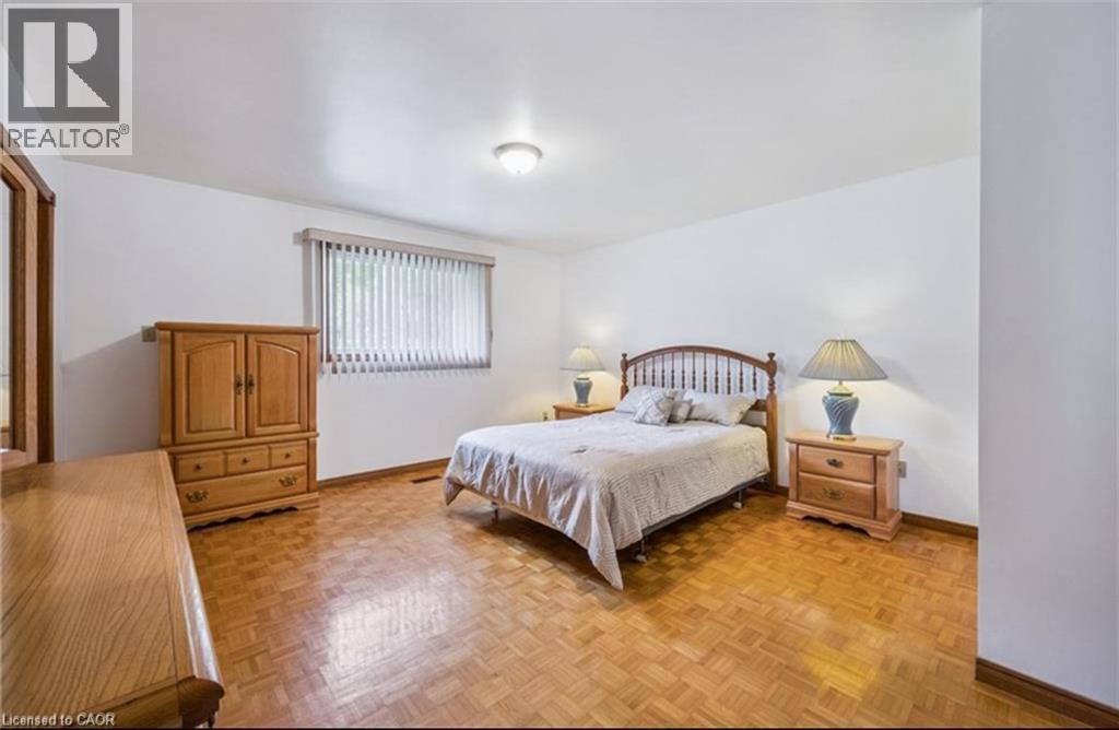 Spacious room featuring parquet wood flooring, white walls, and a window with horizontal blinds - 42 Azores Crescent, Cambridge, ON - Indoor Photo Showing Bedroom