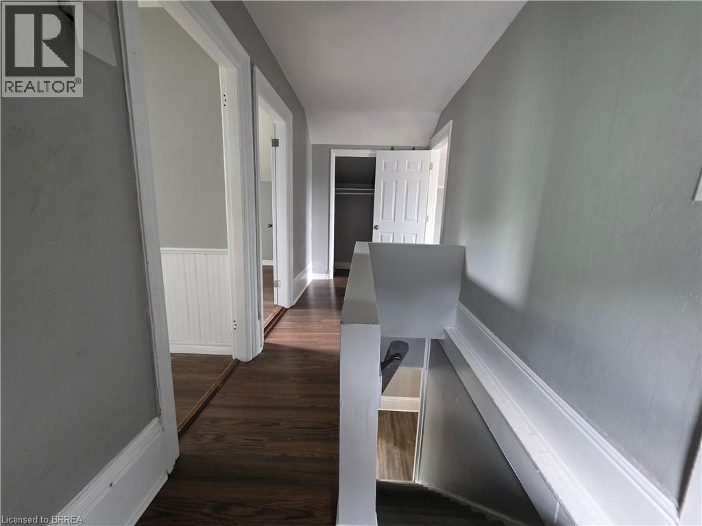 Upper-level hallway featuring wood-finish flooring, light gray walls, and white trim - 109 Sydenham Street, Brantford, ON - Indoor Photo Showing Other Room