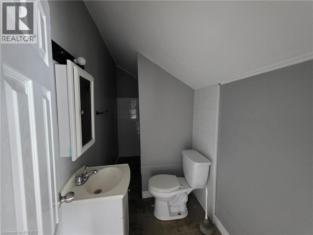 Bathroom featuring a white vanity with integrated sink, chrome faucet, and mirrored medicine cabinet - 109 Sydenham Street, Brantford, ON - Indoor Photo Showing Bathroom