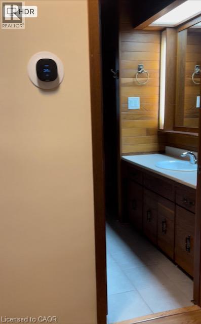 Bathroom vanity featuring wood-finish cabinetry, integrated sink, and a framed mirror - 48 Austin Drive Unit# Upper, Waterloo, ON - Indoor