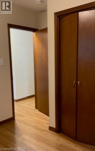 Hallway featuring wood-finish flooring, light-toned wall paint, dark wood trim, and multiple interior doors - 48 Austin Drive Unit# Upper, Waterloo, ON - Indoor Photo Showing Other Room