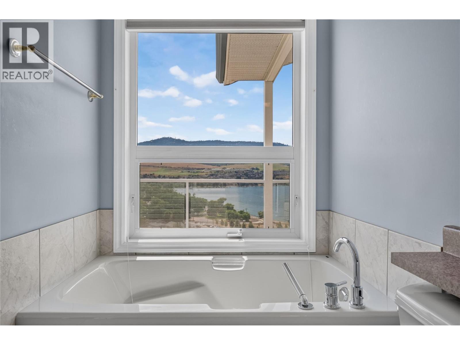 Lake views from the bathtub. - 7083 Jasper Drive, Vernon, BC - Indoor Photo Showing Bathroom