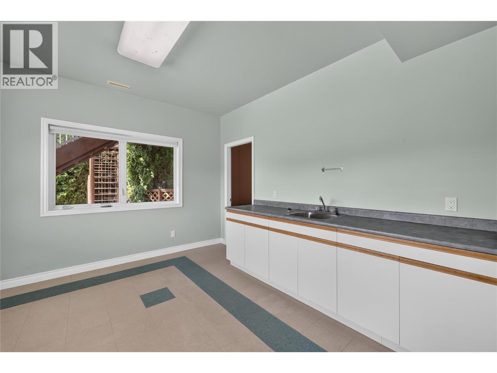 Lower level bar/bonus room with endless possibilities. Perfect as a speakeasy, art studio, hobby room, fitness space, or entertaining lounge. - 7083 Jasper Drive, Vernon, BC - Indoor