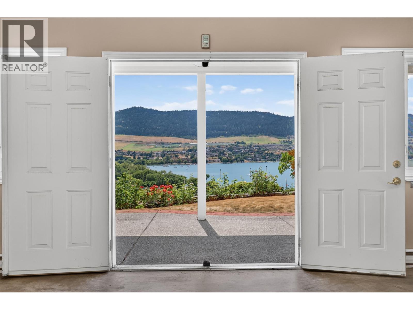 Double doors open into the workspace. - 7083 Jasper Drive, Vernon, BC - Indoor Photo Showing Other Room With Body Of Water
