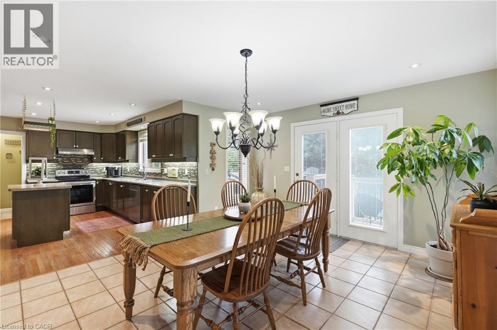 Open-concept kitchen and dining area featuring dark wood cabinetry, stainless steel appliances, a tiled backsplash, and recessed lighting - 5 Manor Crescent, Grimsby, ON - Indoor Photo Showing Dining Room