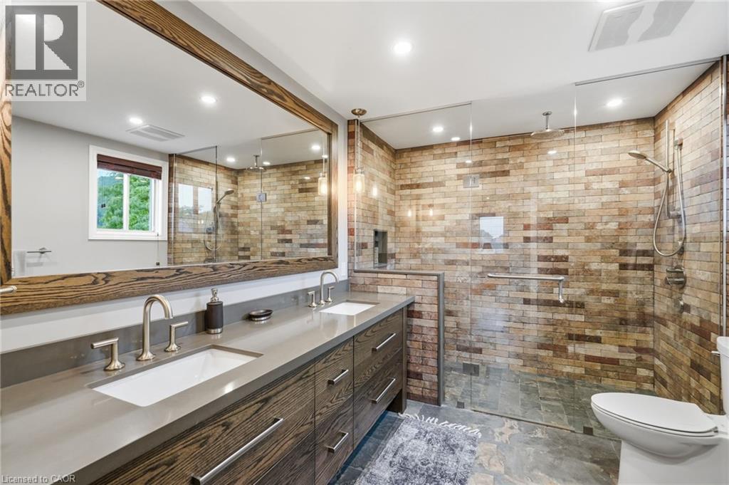 Contemporary bathroom featuring a spacious walk-in shower with brick-look tile walls and a glass enclosure - 5 Manor Crescent, Grimsby, ON - Indoor Photo Showing Bathroom