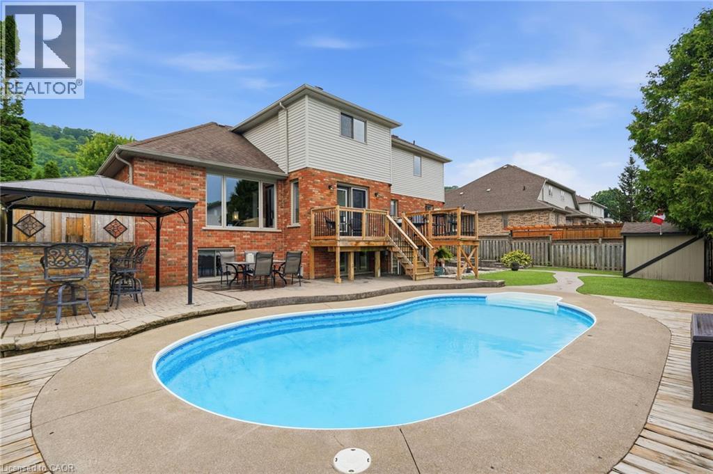 In-ground saltwater pool surrounded by concrete and wood-finish decking - 5 Manor Crescent, Grimsby, ON - Outdoor With In Ground Pool With Deck Patio Veranda With Backyard With Exterior