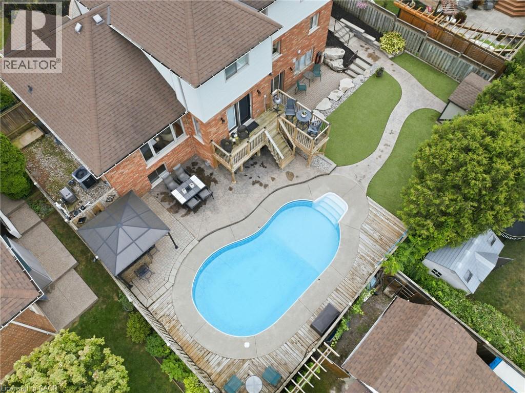 Backyard oasis featuring an in-ground pool, expansive wood decking, brick paver patio, and a gazebo - 5 Manor Crescent, Grimsby, ON - Outdoor With In Ground Pool