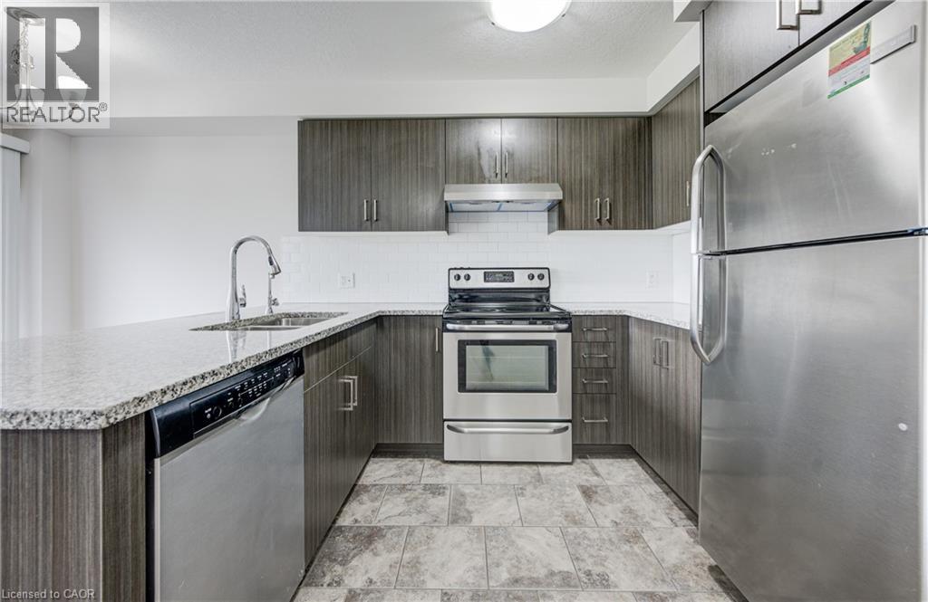 Modern kitchen featuring wood-finish cabinetry, granite-style countertops, stainless steel appliances, a subway tile backsplash, and tile flooring - 823 Paris Boulevard, Waterloo, ON - Indoor Photo Showing Kitchen With Stainless Steel Kitchen With Double Sink With Upgraded Kitchen