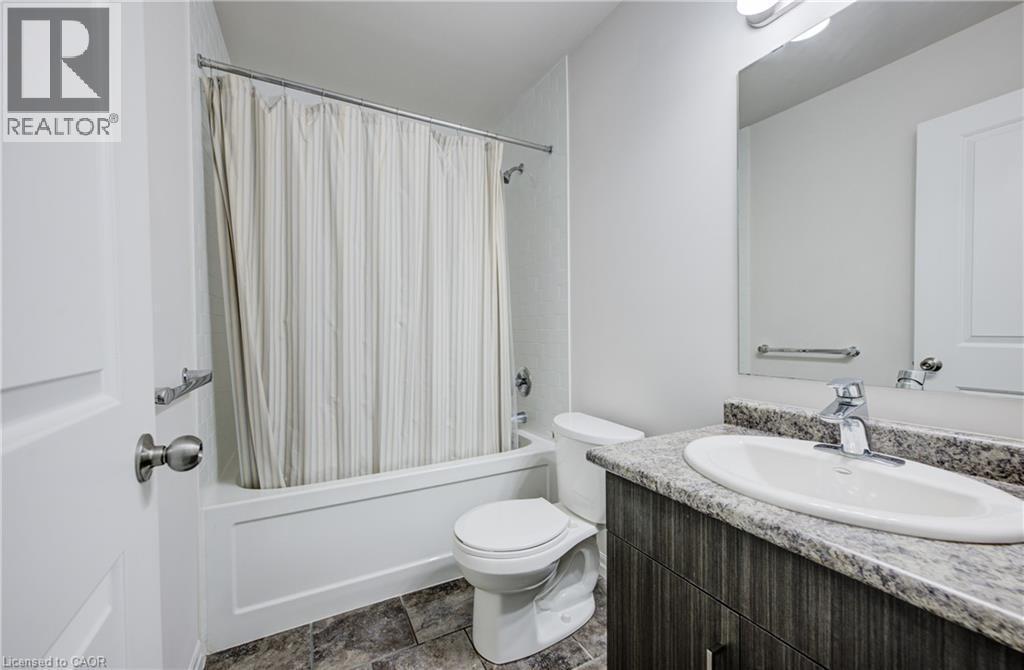Bathroom featuring a single vanity with a granite-style countertop, undermount sink, and chrome faucet - 823 Paris Boulevard, Waterloo, ON - Indoor Photo Showing Bathroom