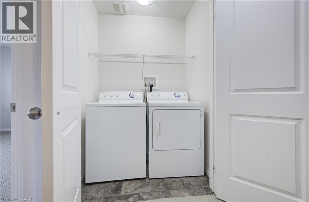Dedicated laundry area featuring a washer and dryer, wire shelving, and durable flooring - 823 Paris Boulevard, Waterloo, ON - Indoor Photo Showing Laundry Room