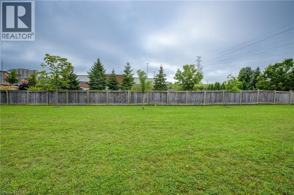 Expansive backyard featuring a lush green lawn and perimeter wooden fencing - 823 Paris Boulevard, Waterloo, ON - Outdoor