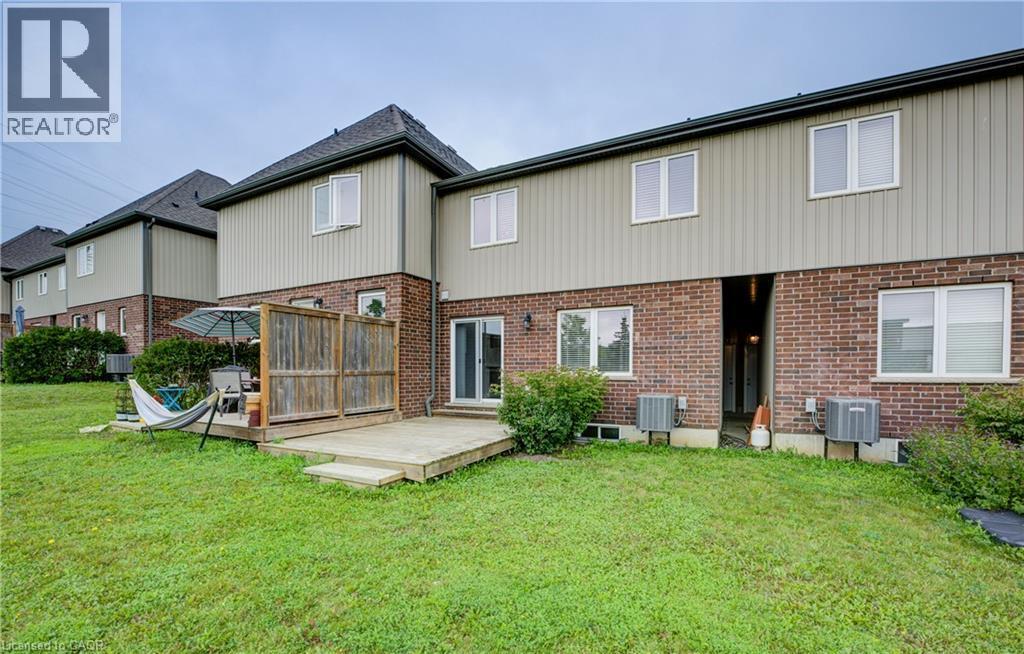 Expansive backyard featuring a manicured lawn, a wooden deck with privacy screening, and mature landscaping - 823 Paris Boulevard, Waterloo, ON - Outdoor With Exterior