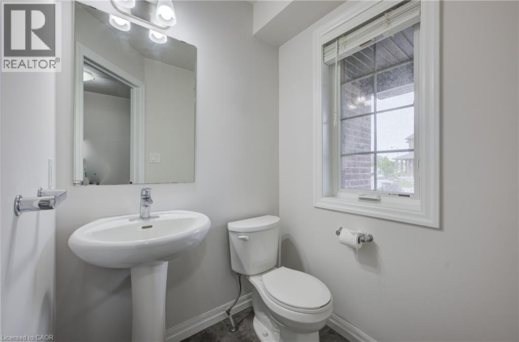 Pedestal sink with chrome faucet, large rectangular mirror, and an overhead vanity light fixture - 823 Paris Boulevard, Waterloo, ON - Indoor Photo Showing Bathroom