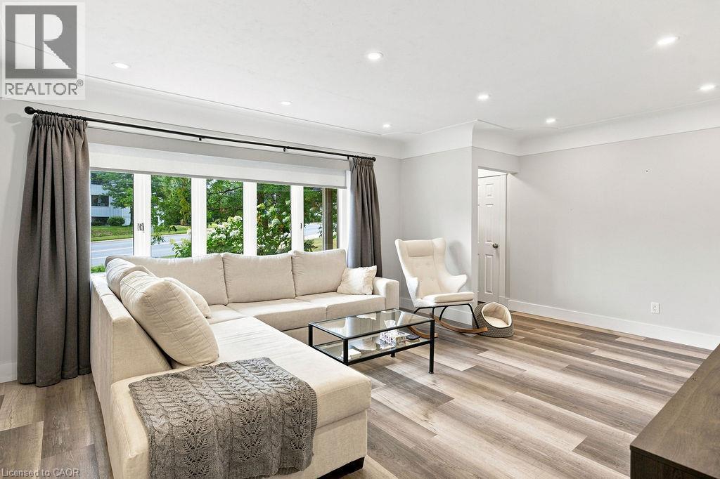 Spacious room featuring wood-finish flooring, recessed lighting, crown molding, and a large bay window - 67 Weber Street S, Waterloo, ON - Indoor Photo Showing Living Room