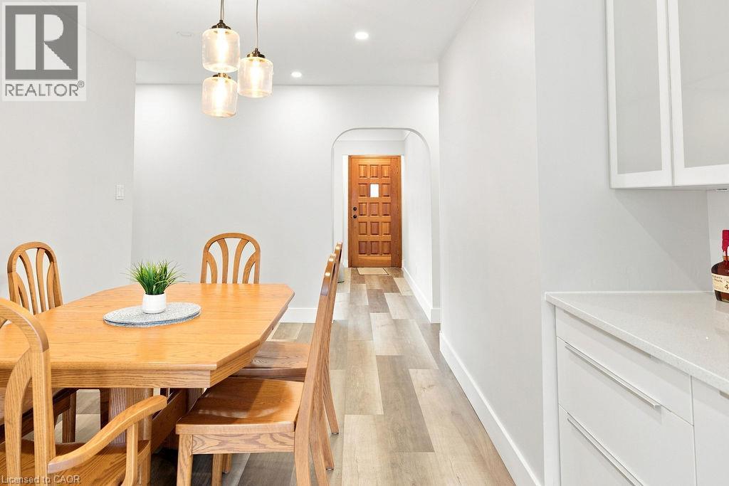 Dining area featuring wood-finish flooring, a contemporary three-light pendant fixture, recessed lighting, and a neutral wall palette - 67 Weber Street S, Waterloo, ON - Indoor Photo Showing Dining Room