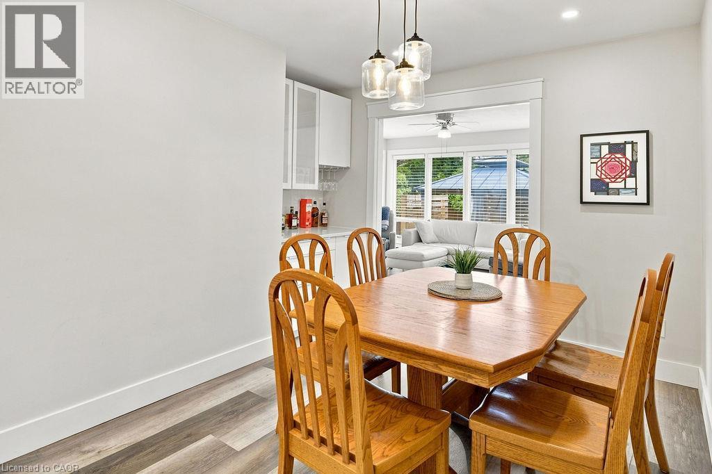 Dining area featuring wood-finish flooring, recessed lighting, and a contemporary three-light pendant fixture - 67 Weber Street S, Waterloo, ON - Indoor Photo Showing Dining Room