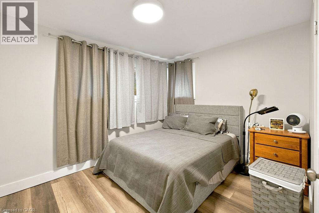 Bedroom featuring wood-finish flooring, a contemporary flush-mount ceiling light, and neutral wall tones - 67 Weber Street S, Waterloo, ON - Indoor Photo Showing Bedroom