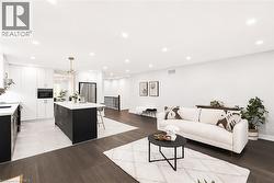 Open-concept living space featuring wood-finish flooring, recessed lighting, and a modern kitchen - 