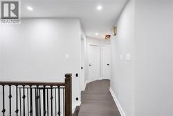 Hallway featuring wood-finish flooring and recessed ceiling lighting - 