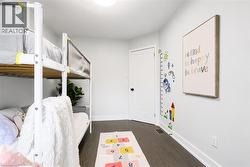 Room featuring dark wood-finish flooring, white baseboards, and a white interior door with black hardware - 