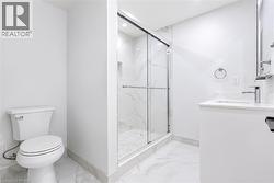 Modern bathroom featuring a glass-enclosed shower with a tiled interior, a built-in shower niche, and a contemporary vanity with an integrated sink - 