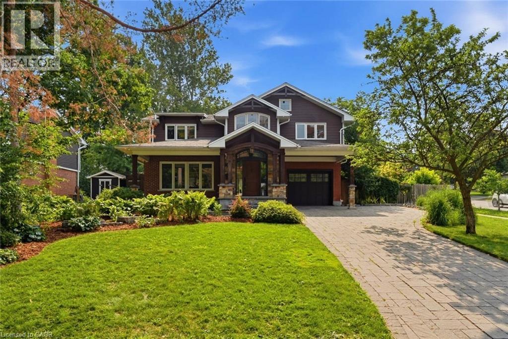 Craftsman-style residence featuring a prominent covered entry with stone accents, dark wood siding, and a paver driveway - 266 Ferndale Place, Waterloo, ON - Outdoor With Facade