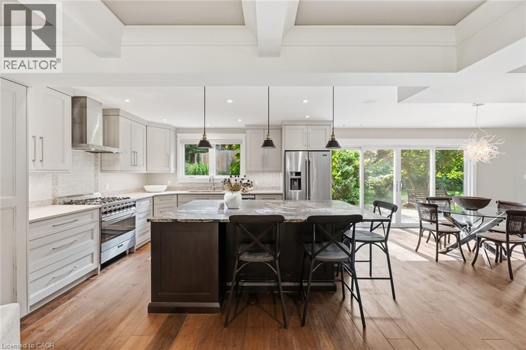 Open-concept kitchen featuring light-toned cabinetry, a spacious island with a darker base, and wood-finish flooring - 266 Ferndale Place, Waterloo, ON - Indoor Photo Showing Kitchen With Upgraded Kitchen